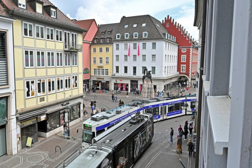 Imagen del Curso de Gestión de Movilidad Sostenible y Segura. Dos tranvías se cruzan circulando por el centro de una ciudad europea.